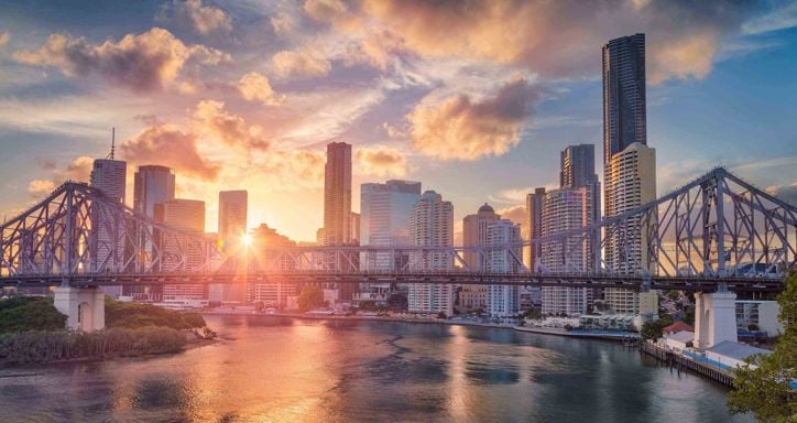 Cityscape image of Brisbane skyline, Australia with Story Bridge during dramatic sunset.