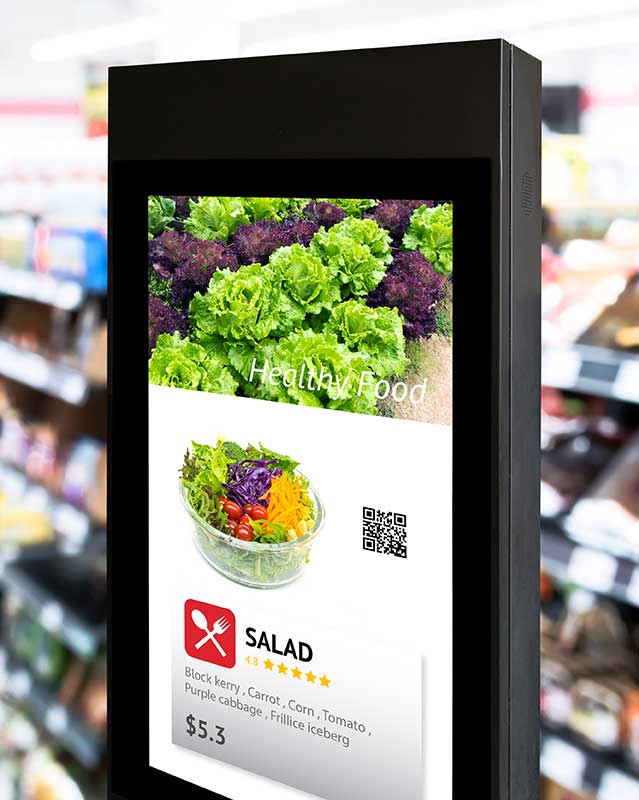 Digital kiosk with healthy food images, including lettuce and a vegetable salad, in a grocery store.