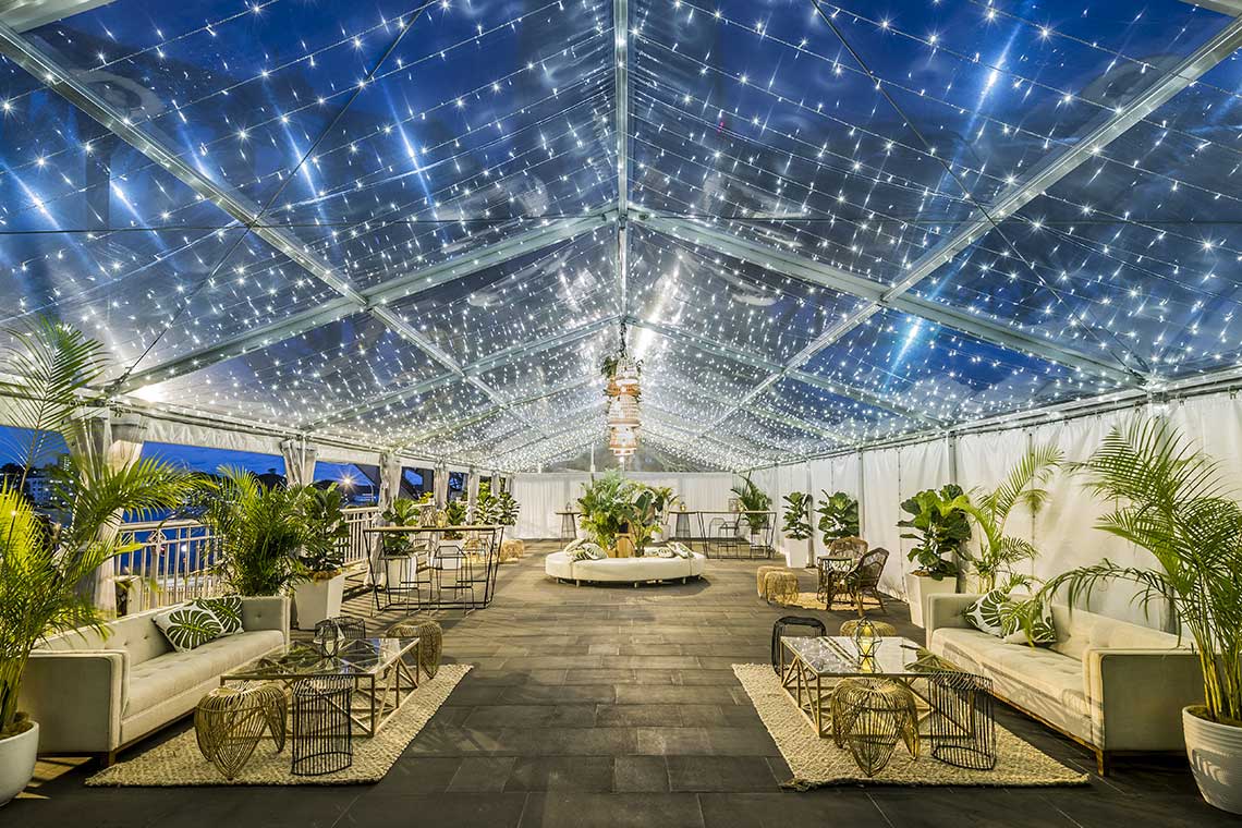 Luxurious event space with twinkling lights under a transparent canopy and elegant seating arrangements.