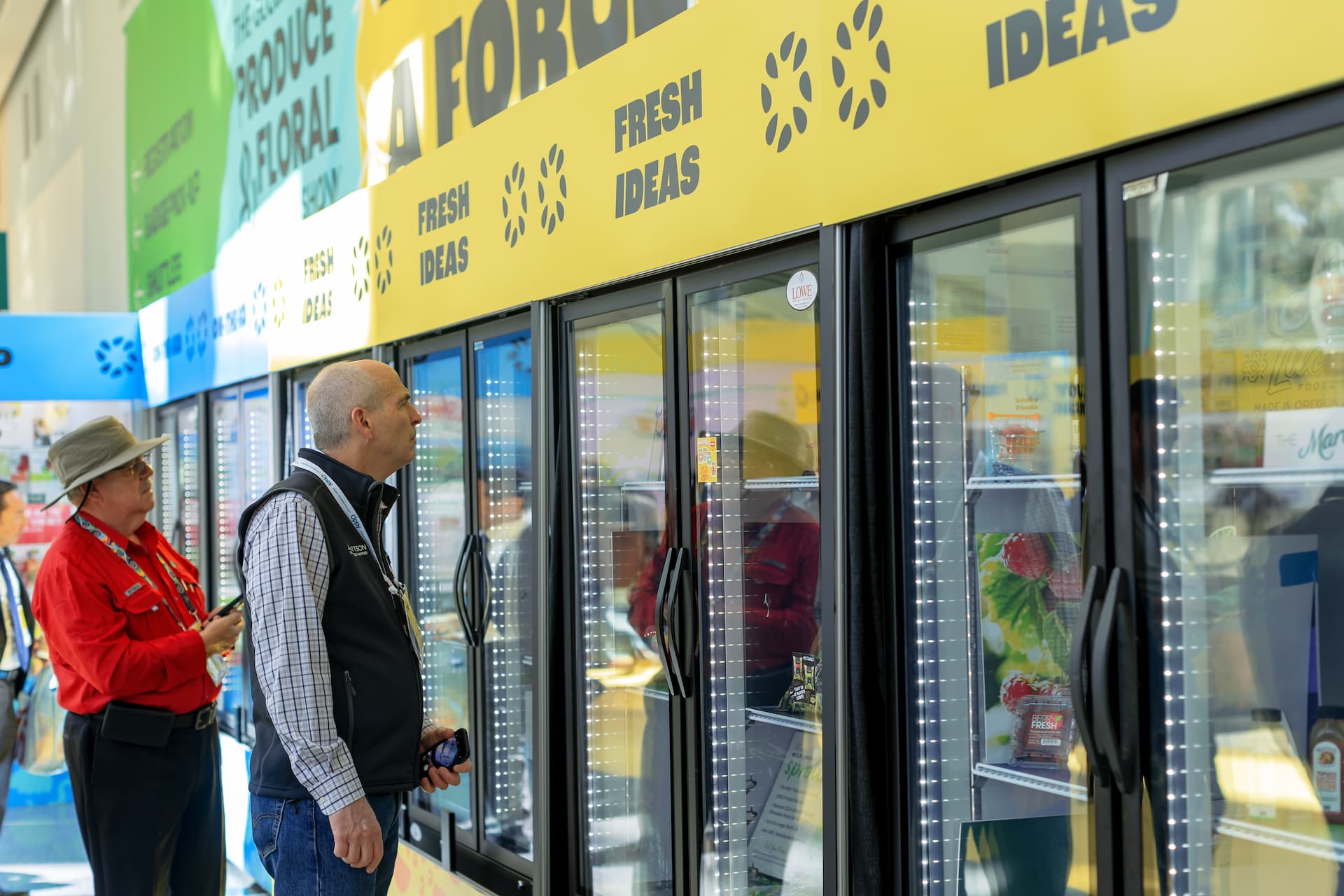Two man looking at fresh flowers on display in a refrigerated display for the Fresh Ideas showcase 2023.