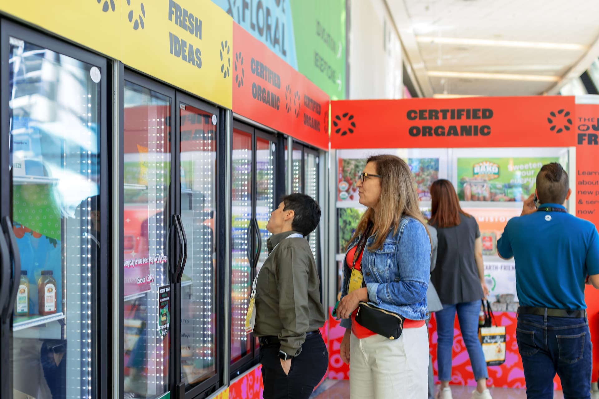 A group of four observe items on display in a refrigerated display at The Fresh Ideas Showcase 2023.