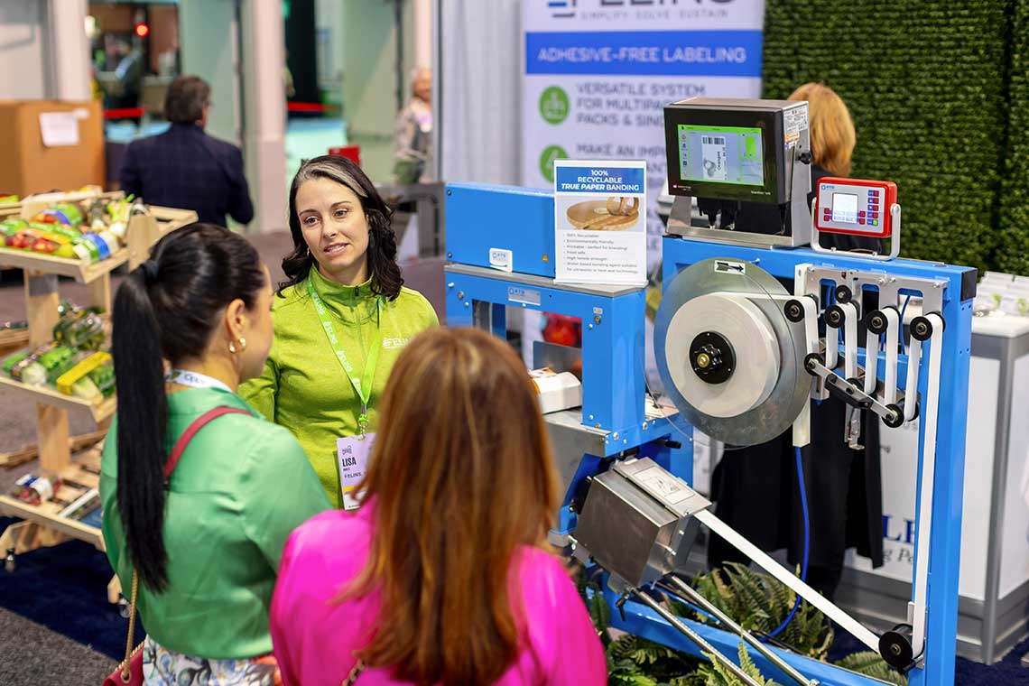 People gathered around a blue machine at a trade show.