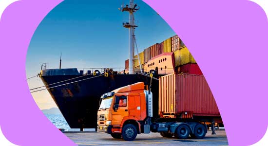 Cargo ship at port with an orange truck and shipping containers.