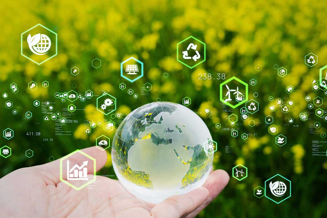 A transparent globe held in a hand with eco-friendly icons floating around and a background of yellow flowers.