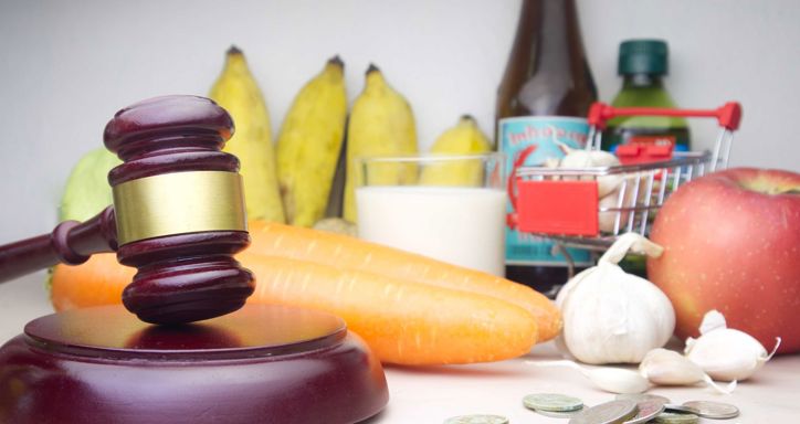 Carrots, garlic, apple, bananas and a gavel used to symbolize regulations for food safety.