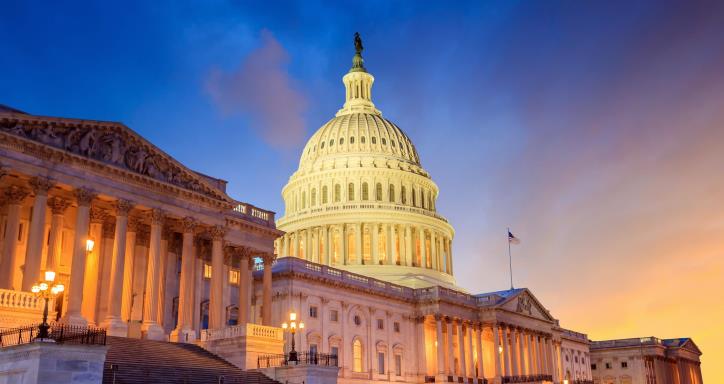 US Capitol glowing during sunset with the sun setting to the right 