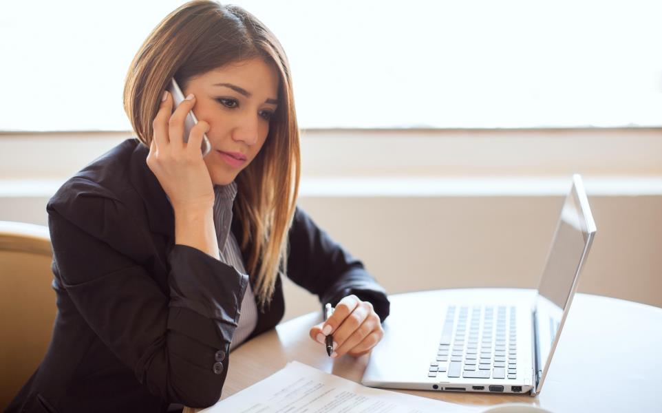 woman on the phone going over deal with someone on the other end of the line.