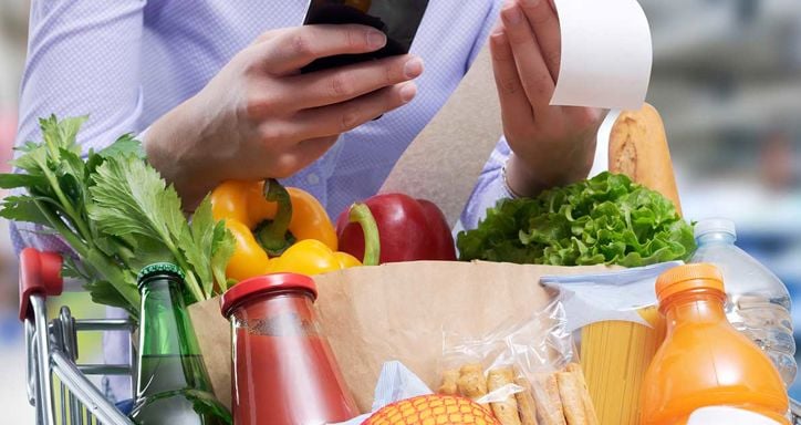 Woman checking the grocery receipt using her smartphone