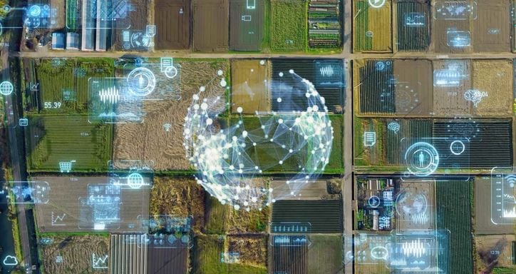 Aerial view of agricultural fields with superimposed digital graphics and icons representing data metrics and technology.