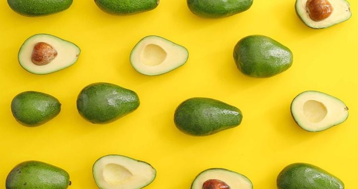 Fresh ripe avocados on color background some with the pit and some without.