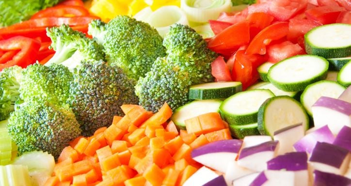 Various cut vegetables laid out on a table in neat rows