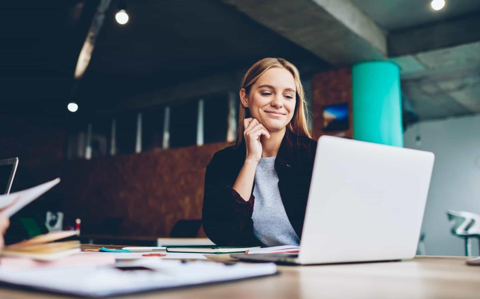 women looking at her laptop smiling