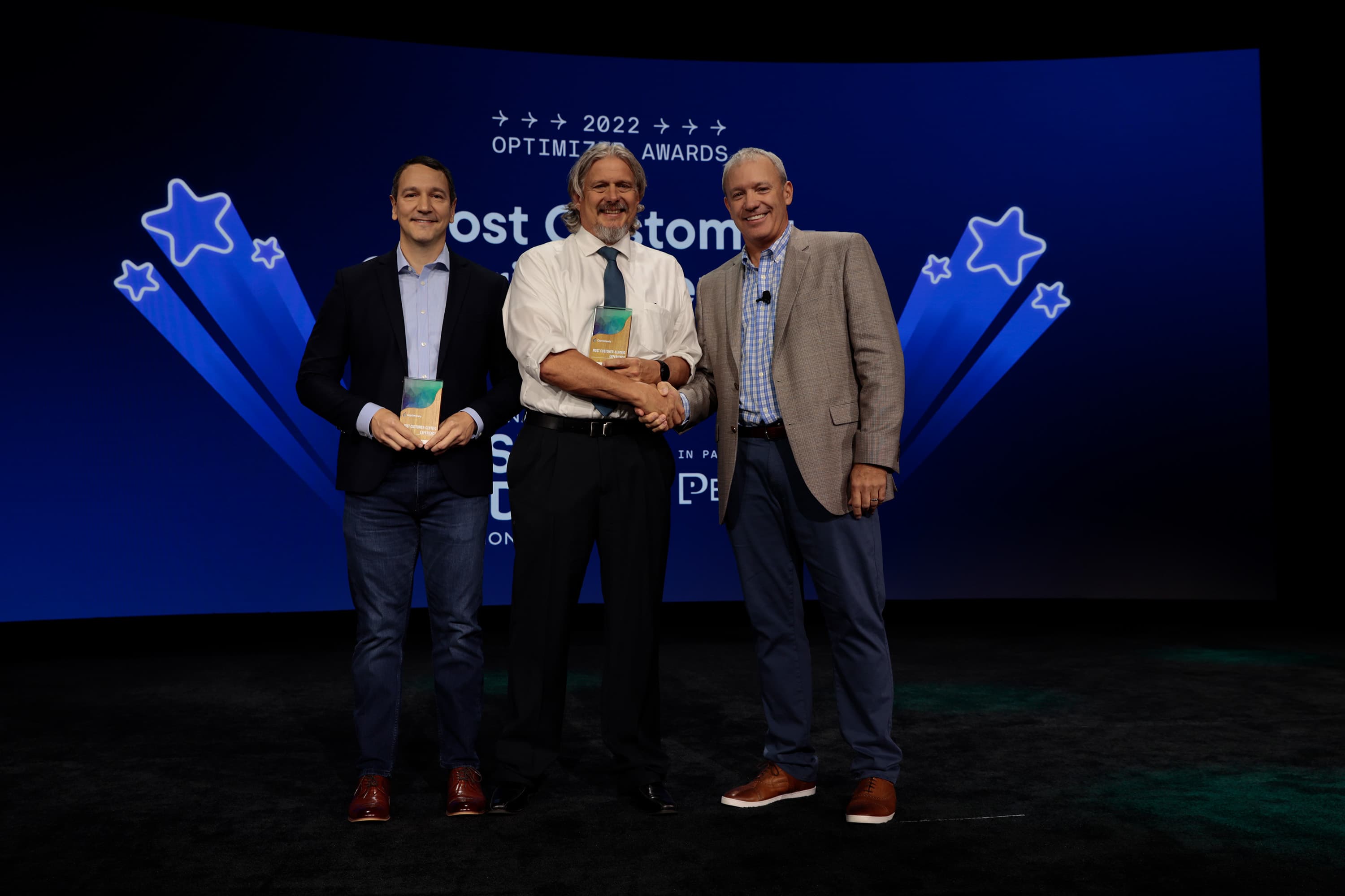 IFPA's Jim Rucinski accepts the Optimizely award for Most Customer Centric website with John Dymond of Perficient from Chad Wolf, EVP, Chief Customer Officer at Optimizely